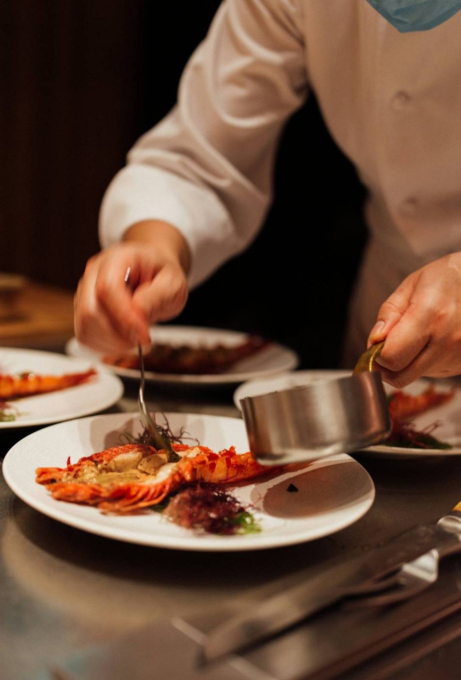 A Chef finishing plates at the pass
